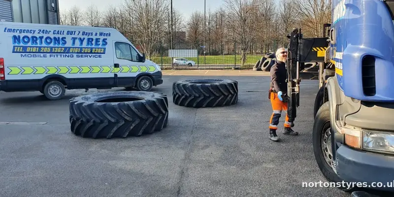 Fitter with large tractor tyres beside the Nortons van Fitter with large tractor tyres beside the Nortons van